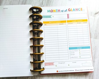 May include: A monthly budget planner with sections for income, fixed expenses, variable expenses, and savings. The planner has a colorful design with yellow, blue, and green accents. The planner is designed to be used with a disc-bound planner system.
