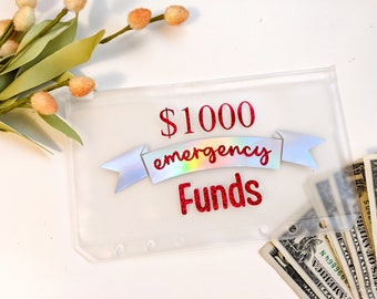 May include: A clear plastic envelope with a red and iridescent sticker that says "$1000 emergency funds". Cash is visible inside the envelope.
