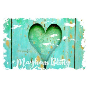 May include: A distressed wooden panel with a carved heart shape. The panel is painted in shades of turquoise and green, with gold-colored paint splatters and the text "Mayhem Bling".