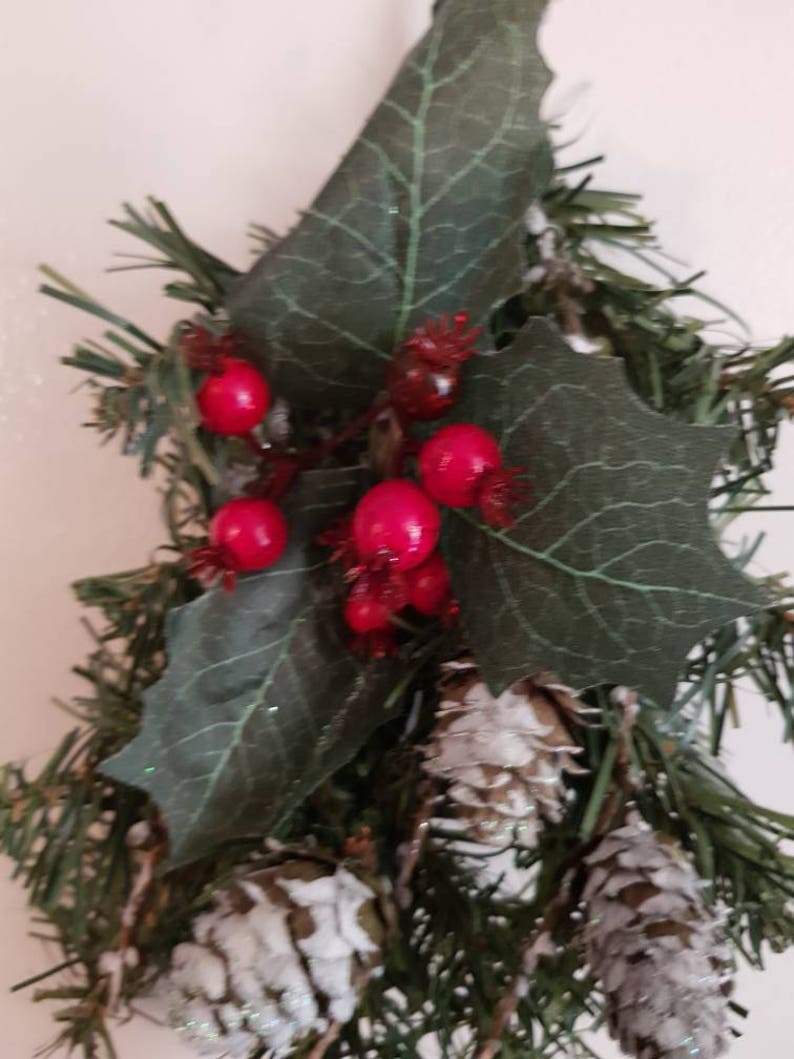 One branch hangers with berries and pine cones.