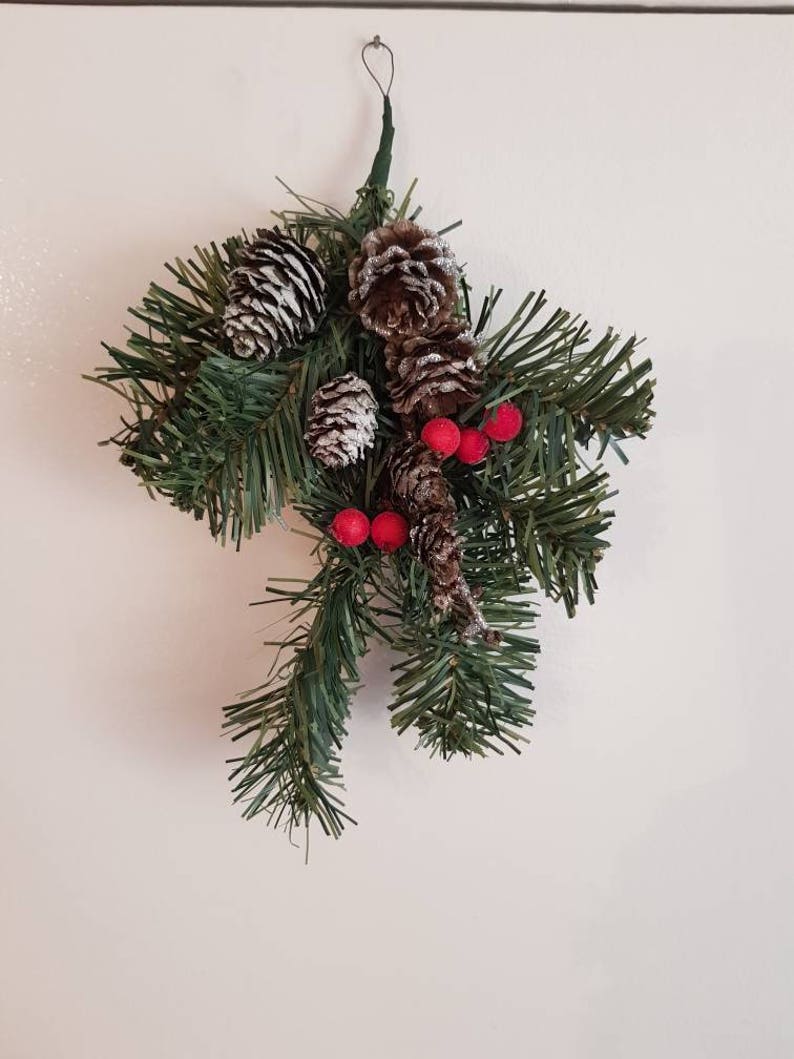 One branch hangers with berries and pine cones.