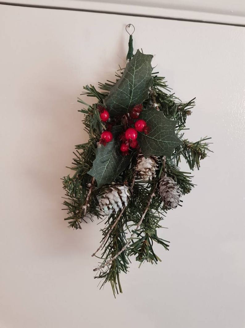 One branch hangers with berries and pine cones.