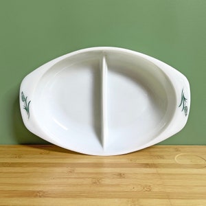 May include: White oval divided serving dish with green wheat stalk design. The dish has two compartments and handles. A vintage piece for serving snacks or appetizers.