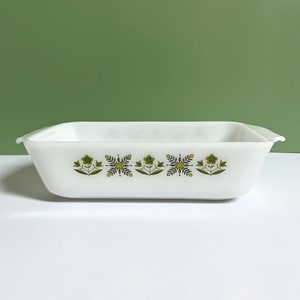 May include: White rectangular baking dish with a green and yellow floral pattern. The dish has a slightly rounded edge.