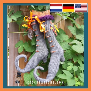 May include: A pair of gray crocheted witch boots with orange and purple accents. The boots have a pointed toe and a curled up heel. The boots are decorated with feathers and beads.