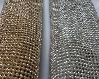 May include: Two rolls of rhinestone mesh fabric, one gold and one silver. The mesh is made of small, round rhinestones.
