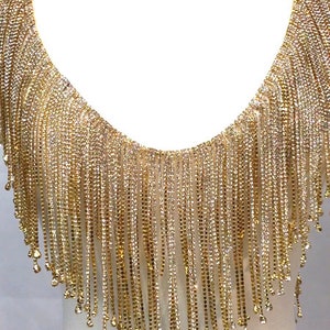 May include: Gold fringe trim with crystal embellishments. The fringe is approximately 10 inches long.