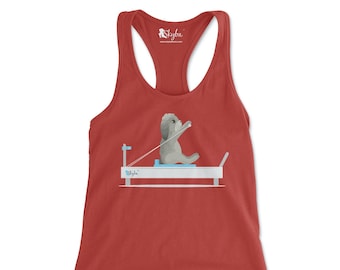 May include: Red tank top with a white graphic of a dog doing a rowing exercise on a reformer machine. The graphic includes the text "Skyba".
