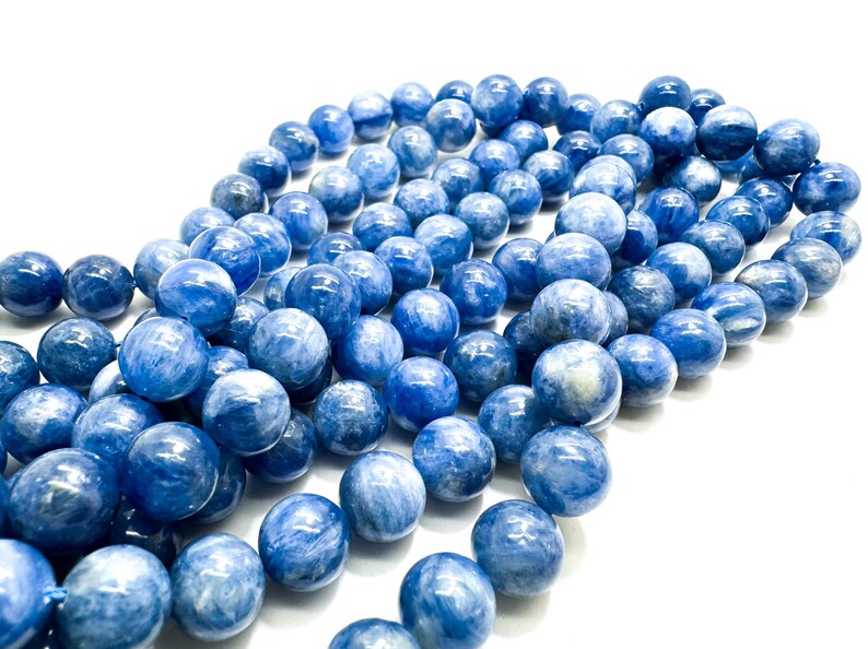 Peut inclure: Un brin de perles de pierres pr&eacute;cieuses bleues et blanches. Les perles sont rondes et ont une finition lisse et polie.