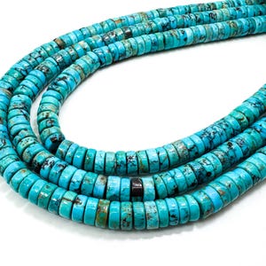 Op de afbeelding: Dichtbij van strengen turkoois edelsteen kralen. De kralen hebben een heldere turkoois tint met bruine en zwarte matrixpatronen. De platte, schijfvormige kralen zijn geregen, geschikt voor het maken van sieraden.