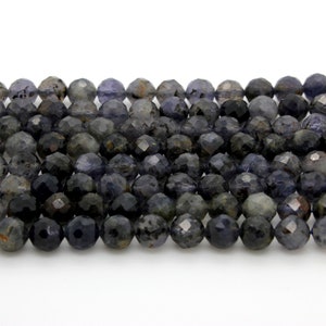 May include: A strand of dark blue faceted gemstone beads. The beads are round and have a slightly iridescent finish.