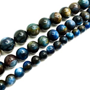May include: A strand of blue and brown gemstone beads. The beads are round and have a smooth, polished finish.