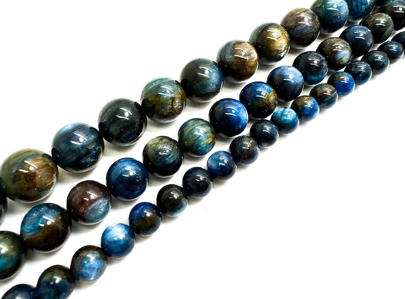May include: A strand of blue and brown gemstone beads. The beads are round and have a smooth, polished finish.