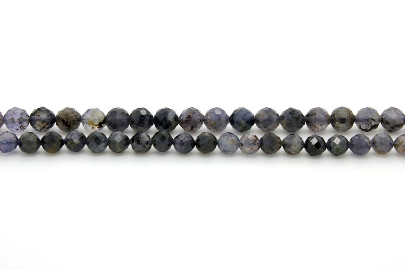 May include: A strand of dark blue faceted gemstone beads. The beads are round and have a slightly irregular shape.