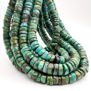 May include: A strand of turquoise beads featuring a disc shape with a flat profile. The beads display a range of natural blue and green hues, with dark brown and black matrix inclusions visible throughout the surface of each individual stone piece.
