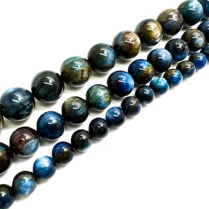 May include: A strand of blue and gold tiger's eye beads. The beads are round and have a smooth, polished finish.