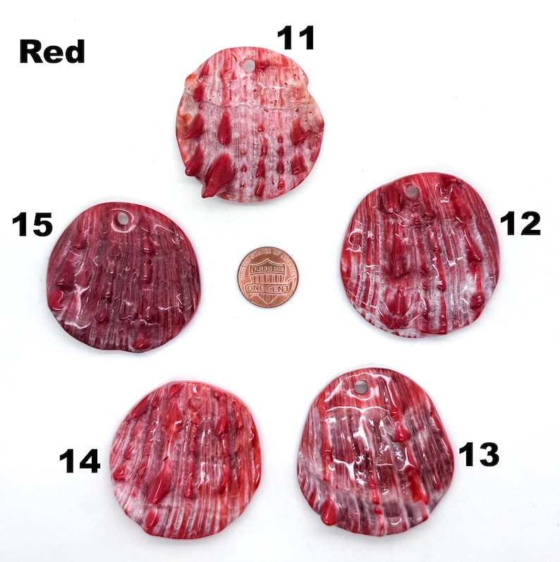 May include: Five red, textured shell pendants with drilled holes for jewelry making. The shells vary in shape and size, with a penny for scale. The word "Red" is in the upper left corner, and numbers 11-15 are next to each shell.