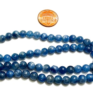 Peut inclure: Un brin de perles d'apatite bleue, d'environ 8 mm de diam&egrave;tre, avec un penny pour comparaison de taille.