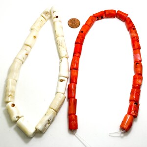 May include: Two strands of coral beads, one white and one orange. The beads are cylindrical and have a rough, natural texture.