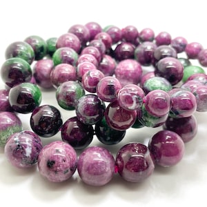 May include: A set of three bracelets made of green and pink gemstone beads. The beads are round and have a smooth, polished finish.