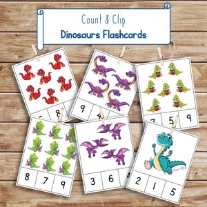 May include: Count & Clip Dinosaurs Flashcards: A set of six flashcards featuring colorful cartoon dinosaurs with numbers to count. Each card has a different dinosaur and a number grid to match the number of dinosaurs on the card.