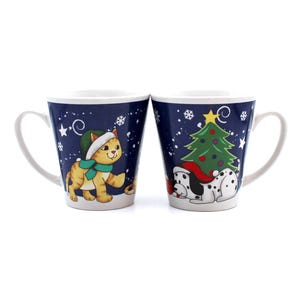 Op de afbeelding: Twee keramische mokken met een winterse kerstthema. De ene mok heeft een kat met een kerstmanmuts en de andere mok heeft een hond met een kerstmanmuts. Beide mokken hebben een blauwe achtergrond met witte sneeuwvlokken en een groene kerstboom.