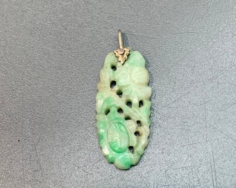 May include: A green jade pendant with intricate floral carvings and a gold-toned bail.