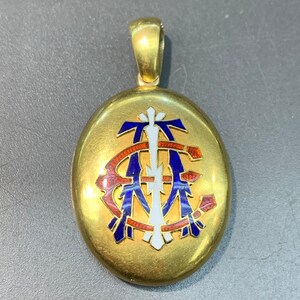 May include: Gold oval locket with a blue, red, and white enamel monogram.