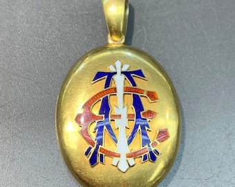 May include: Gold oval locket with a blue, red and white enamel monogram.