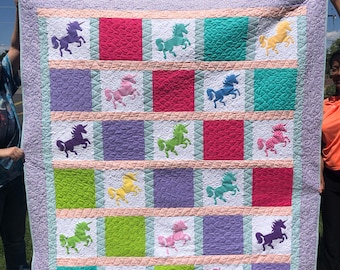 Handgjord applikationsquilt med enhörning och ljus flerfärgad flicka