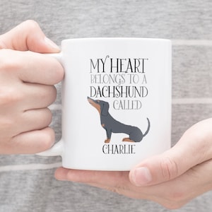 May include: White ceramic mug with a black dachshund illustration and the text "My heart belongs to a dachshund called Charlie".
