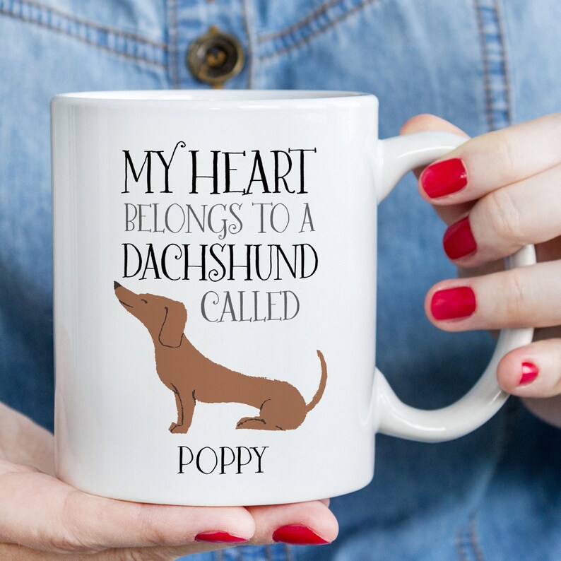 May include: White ceramic mug with a brown dachshund illustration and the text "My heart belongs to a dachshund called Poppy".