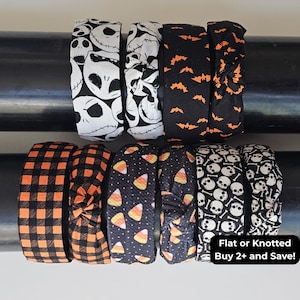 Può includere: Una collezione di dieci fasce per capelli in tessuto con vari motivi a tema Halloween, tra cui teschi bianchi, pipistrelli arancioni, motivo a quadri arancione e nero e caramelle a forma di mais. Alcune sono piatte, altre annodate. Testo: Flat or Knotted Buy 2+ and Save!