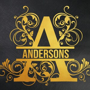 May include: Gold monogram with the letter A and the name Andersons in a decorative font. The letter A is surrounded by ornate floral designs.