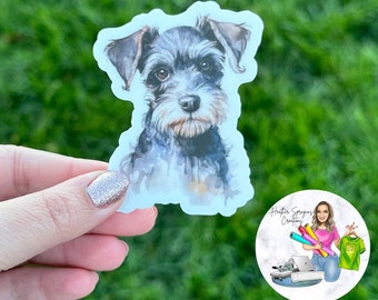 Peut inclure: Une illustration à l'aquarelle d'un schnauzer noir et gris sur un autocollant blanc. Le chien regarde directement le spectateur avec une expression sérieuse.