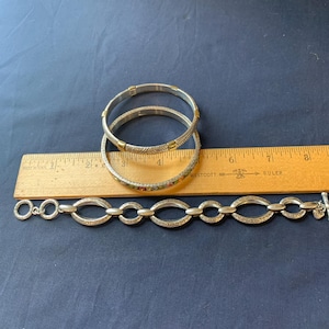 May include: A white ceramic mug with a black handle and the text "But First, Coffee" in a black, handwritten-style font. The mug is on a white surface.