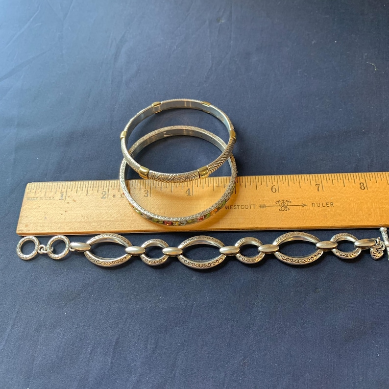 May include: A white ceramic mug with a black handle and the text "But First, Coffee" in a black, handwritten-style font. The mug is on a white surface.