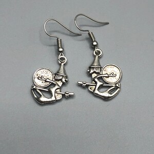 Pendientes de la bruja montando una escoba