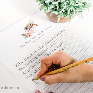 Pode incluir: Uma folha de papel pautado com o poema "The Bees and the Blossoms" de John B. Tabb, com uma ilustra&ccedil;&atilde;o de abelha e flores. Uma m&atilde;o escreve com um l&aacute;pis amarelo. Uma pequena planta em vaso est&aacute; no fundo.