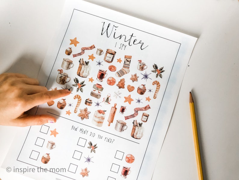 May include: A printable winter-themed I Spy game with a white background and colorful illustrations of winter items. The game includes a list of items to find, such as mugs, stars, and candy canes. The text "Winter I Spy" is at the top of the page. The text "How many did you find?" is below the image.