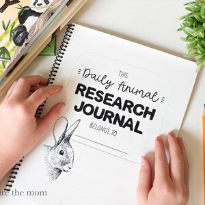 May include: A spiral-bound Daily Animal RESEARCH JOURNAL with a white cover featuring black text and a detailed black and white illustration of a rabbit head. The cover includes the printed text THIS Daily Animal RESEARCH JOURNAL BELONGS TO.