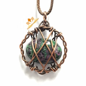 May include: A green and purple gemstone pendant with a copper wire cage. The pendant is hanging from a copper chain.