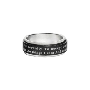 May include: A silver-tone spinner ring with a black band. The band features the engraved text: "the serenity To accept the things I can; And wisdom". The ring has a polished finish and a simple design.