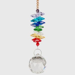 May include: A decorative crystal suncatcher with a rainbow of colored crystal accents. The suncatcher has a clear crystal ball at the bottom and a gold chain at the top. The crystals are arranged in a vertical line.