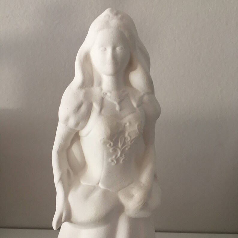 May include: White ceramic figurine of a woman with long hair and a detailed floral design on her dress.