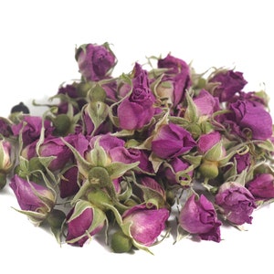 May include: A pile of dried rose buds, a popular ingredient for tea and aromatherapy. The buds are a deep purple color and have a delicate, floral scent.