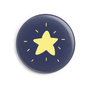 Könnte beinhalten: Ein marineblauer Knopf mit einem gelben Stern in der Mitte. Der Stern hat einen leuchtend gelben Schein um sich herum.