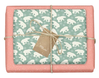 Può includere: Una scatola regalo avvolta con un motivo a pois rosa e bianco. La scatola è legata con uno spago e ha un'etichetta di carta marrone su cui è scritto "Buon Natale". La carta da regalo presenta un motivo ripetuto di orsi polari bianchi su uno sfondo blu chiaro.