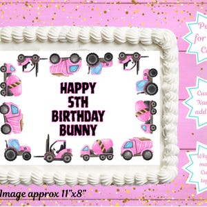 May include: A rectangular cake with white frosting and a decorative border. The cake features a pink and black design with the text "HAPPY 5TH BIRTHDAY BUNNY" and images of construction vehicles. The edible image is approximately 28cm x 20cm.