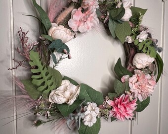 May include: A pink and white floral wreath with greenery and pink pampas grass. The wreath is made of artificial flowers and is perfect for a spring or summer decor.